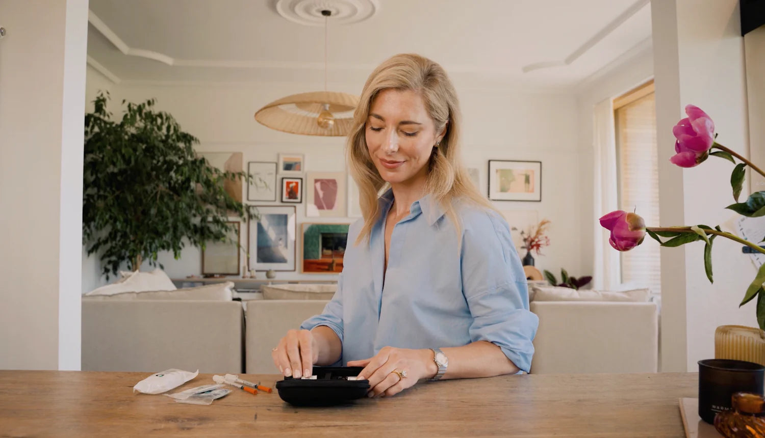 Woman sitting at a table in a modern living room, using a NAD SQ